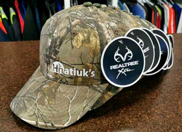 Heat printed hats for Hnatiuk's Hunting and Fishing retail store. Hats, Toques, Fitted Hats, Ball Caps